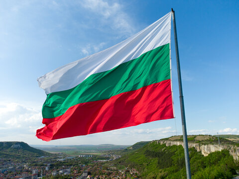 Bulgaria National Flag Waving on pole against sunny blue sky background
