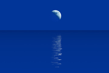 Crescent moon and moonlight path in water surface