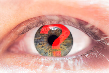 Close-up of an eye in selective focus with a reflection of a question mark. Concept on the topic of...