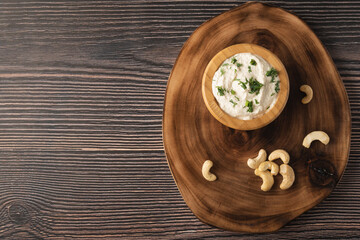 Vegetarian cream cheese made from fermented cashews on dark wooden background. Copy space.