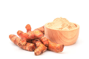 Fresh turmeric and extract powder in wooden bowl.