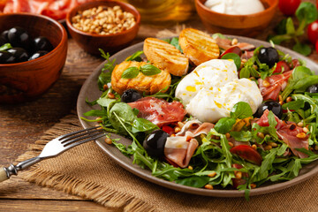 Salad with burrata cheese and croutons.
