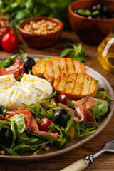 Salad with burrata cheese and croutons.
