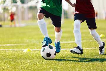 Two Kids Playing Football Ball on Grass Field. Happy School Boys Kicking Ball During Tournament Game. Children in Blue and Red Soccer Team