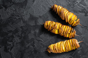 Twisted tornado potatoes chips. Black background. Top view. Copy space