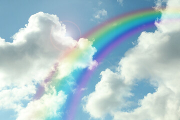 Beautiful view of bright rainbow in blue sky on sunny day