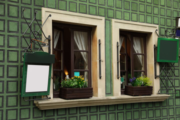 Building with open windows and flower decor, view from outdoors