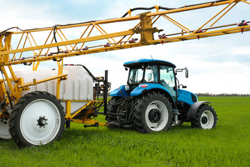 Tractor spraying pesticide in field on sunny day. Agricultural industry