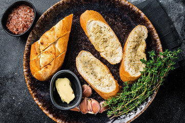 Garlic Spread on Toasted Baguette with Salt, Pepper, Thyme and Olive Oil in plate. Black...