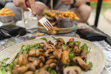 Close up of grilled mushrooms on a plate with greens