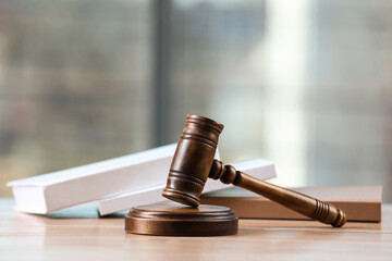 Wooden gavel and books on table indoors