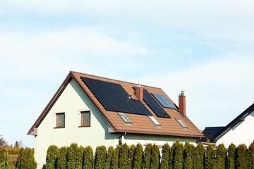 House with installed solar panels on roof, space for text. Alternative energy