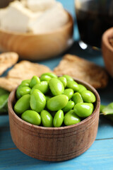 Fresh green soy beans and other organic products on light blue wooden table, closeup
