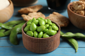 Fresh green soy beans and other organic products on light blue wooden table, closeup