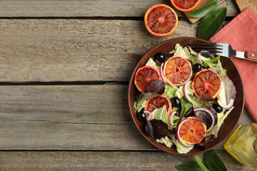 Delicious sicilian orange salad served on wooden table, flat lay. Space for text