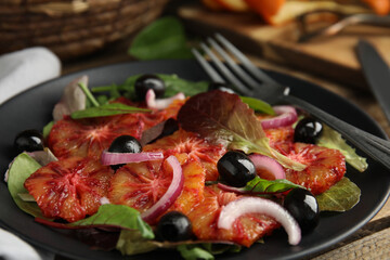 Plate of delicious sicilian orange salad on wooden table, closeup