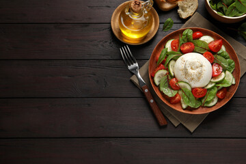 Fototapeta na wymiar Delicious burrata salad served on wooden table, flat lay. Space for text