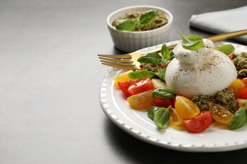 Delicious burrata salad served on grey table. Space for text