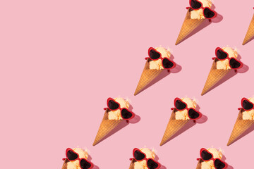 Summer creative pattern with melting ice cream cone and heart shaped sunglasses on pastel pink background. 80s or 90s retro fashion aesthetic ice cream concept. Romantic food Valentines day idea.