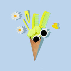 Summer creative layout with ice cream cone and neon yellow scrunchy, hair pins, combs and white sunglasses and flowers on pastel blue background. 80s or 90s retro fashion aesthetic hair salon idea.