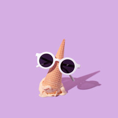 Summer creative layout with ice cream cone upside down and white sunglasses on pastel purple background. 80s or 90s retro fashion aesthetic ice cream concept. Minimal summer idea.