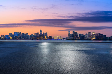 Empty asphalt road and modern city skyline with buildings in Hangzhou at sunrise, China.