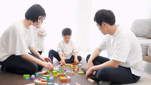 5歳の男の子と1歳4ヶ月の女の子とつみきで遊ぶ両親