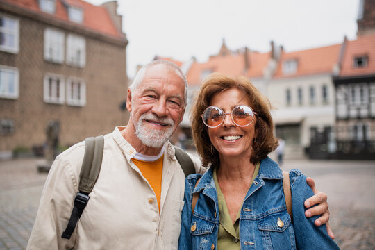Happy senior couple tourists outdoors in historic town