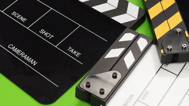 Close up of 3 clapper boards oR movie slate on the green background floor.