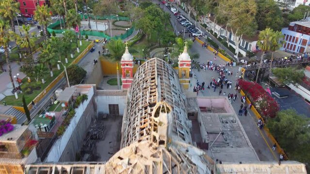 Drone video of an old delapidated church in Lima, Peru that is almost fallen down. In district of Barranco. Drone slowly flies forward, over the church.