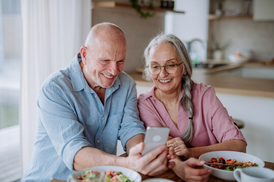 Happy Senior Couple Eating Dinner Together At Home.