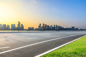Fototapeta premium Asphalt road and modern city skyline with buildings in Hangzhou at sunset, China.