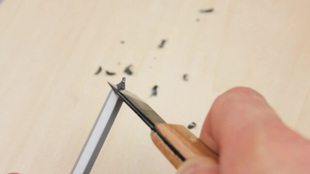 Sharpening a pencil with a knife close-up. Cutting a pencil with a knife.
