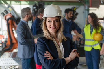 Portrait of female chief engineer in modern industrial factory looking at camera.