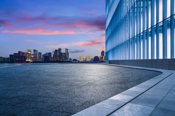 Empty square floor and city skyline with modern commercial buildings in Hangzhou at sunrise, China.