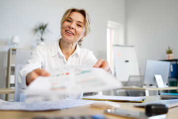 Mature office worker gives documents