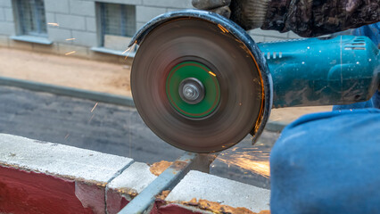 Close-up view of a worker working with angle grinder. Electric wheel grinding on steel structure. Sparks.