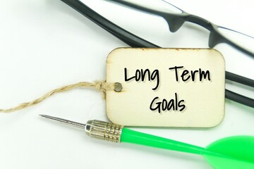 glasses, arrows and wooden tags with the words long term goals
