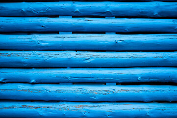 Log wall, bright blue. Wooden textured background. Copy space.