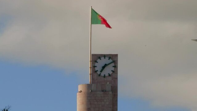 Close-up of the clock tower in Figueira da Foz, with blue sky and clouds.