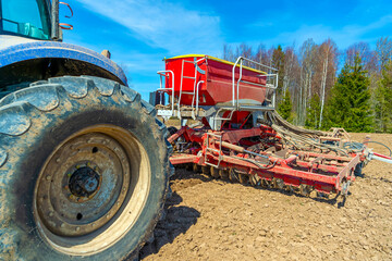 Tractor seeder in the field sows grains of wheat or oats for growing grain products. Close-up.