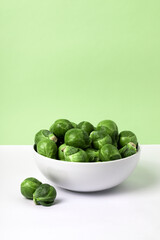 Brussels sprouts on a plate on a white and green backgrounds