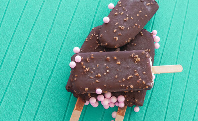 Ice Creams on sticks with pink candies  on turquoise background