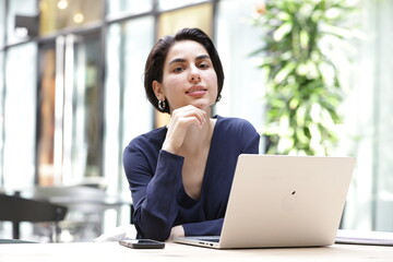 Portrait of young businesswoman using laptop in office