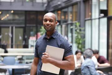 Portrait of businessman holding tablet in office