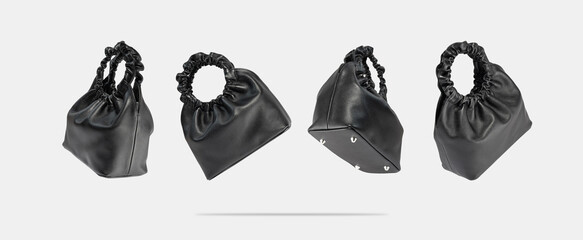 Set of black eco leather bags from different sides flying on a gray background.Creative composition of a levitating handbag. Conceptual banner of fashionable women's accessories. Vegan friendly bag