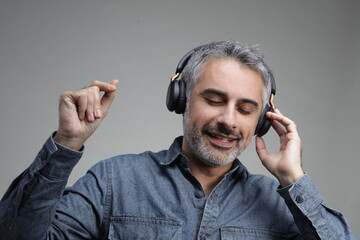 Mature man listening to music on headphones