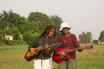 Naklejka premium Two young women playing guitars
