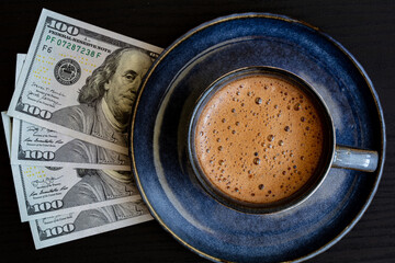 cup of coffee on 100 dollar banknotes background
