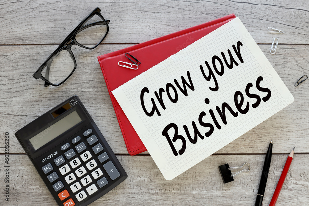 Poster grow your business red notepad with text on the table